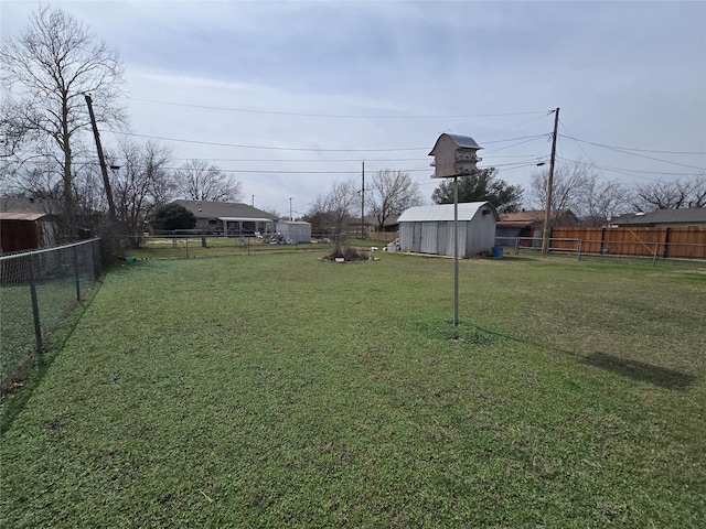 view of yard with an outbuilding, a storage shed, and a fenced backyard