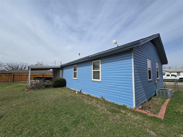 rear view of property featuring a yard, central air condition unit, and fence