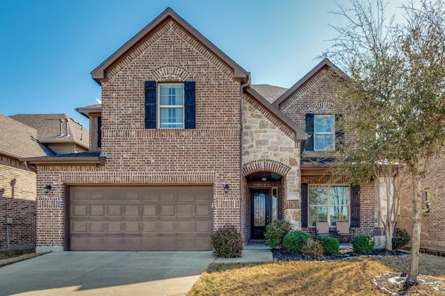 view of front facade featuring concrete driveway, an attached garage, brick siding, and stone siding