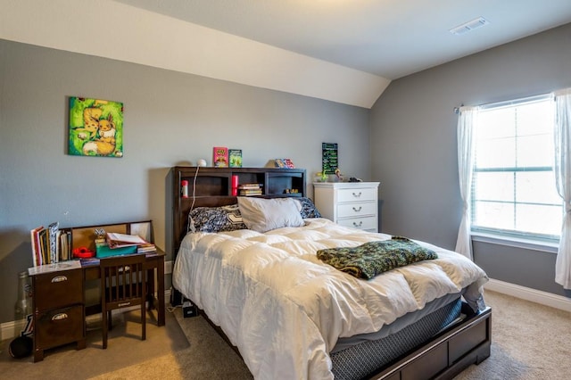 bedroom featuring visible vents, lofted ceiling, light colored carpet, and baseboards