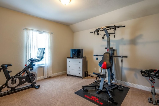 exercise area featuring lofted ceiling, carpet flooring, and baseboards