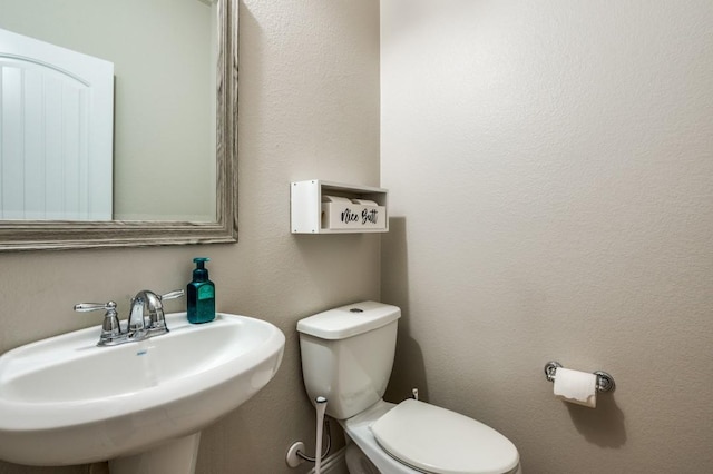 half bathroom with toilet and a sink