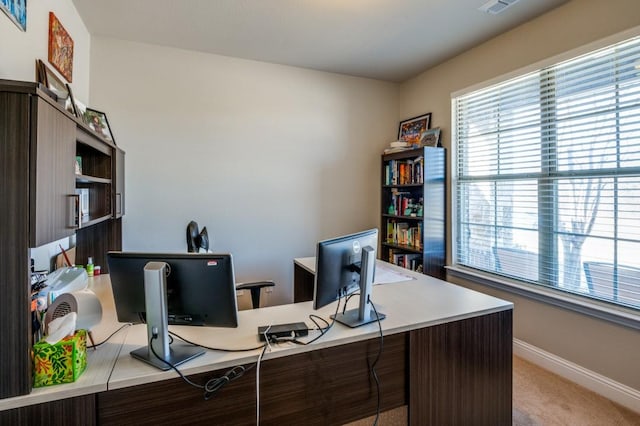 office featuring visible vents, baseboards, and light carpet