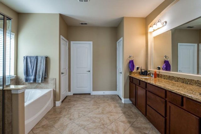 bathroom with visible vents, baseboards, a garden tub, and vanity