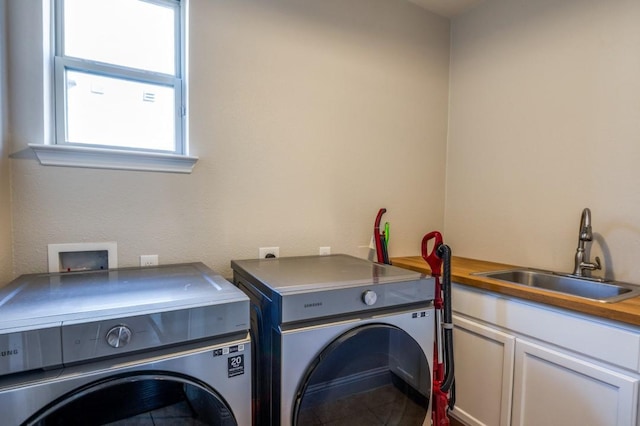 washroom featuring a sink, cabinet space, and washer and dryer