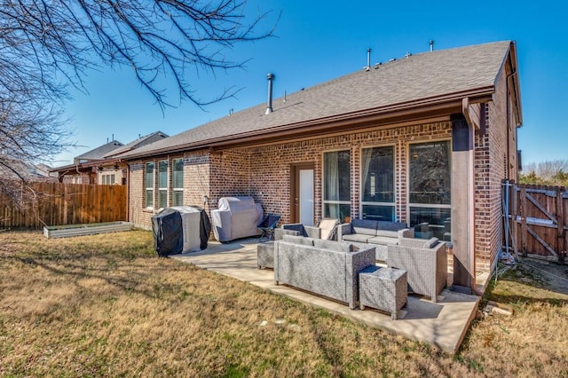 rear view of house featuring brick siding, outdoor lounge area, a yard, and fence