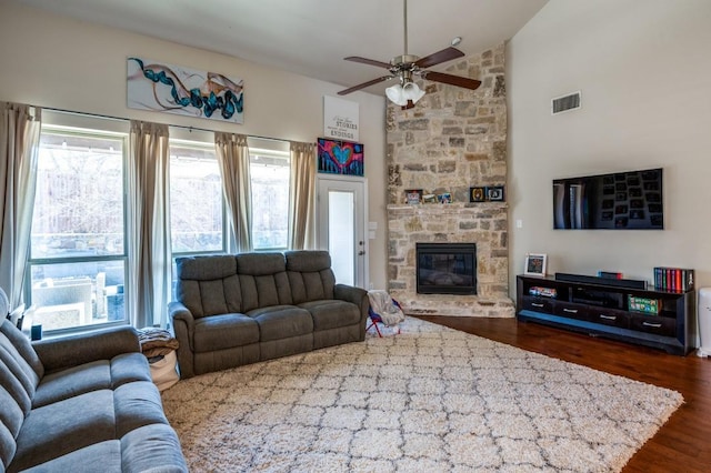 living room featuring visible vents, a fireplace, high vaulted ceiling, a ceiling fan, and dark wood-style flooring