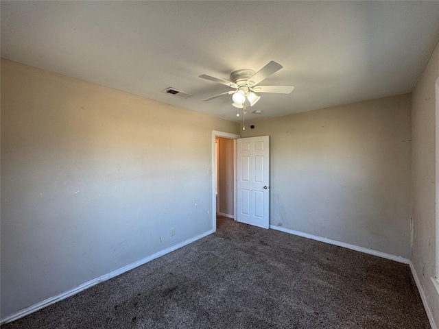 carpeted spare room with visible vents, baseboards, and ceiling fan