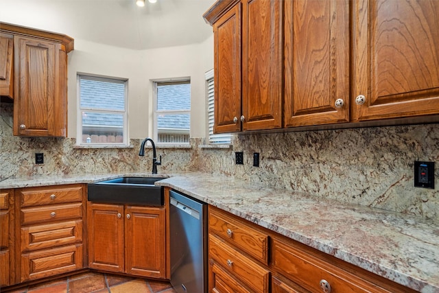 kitchen featuring a sink, brown cabinets, dishwasher, and light stone countertops