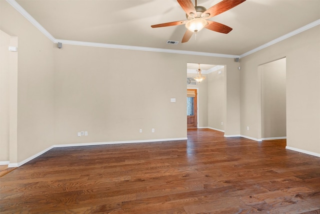 empty room featuring visible vents, baseboards, wood finished floors, and crown molding