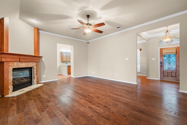 unfurnished living room with a stone fireplace, crown molding, wood finished floors, and baseboards