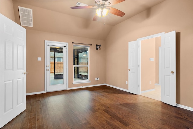 empty room featuring visible vents, baseboards, wood finished floors, and vaulted ceiling