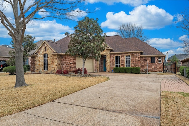 single story home featuring brick siding, concrete driveway, a front yard, roof with shingles, and a garage