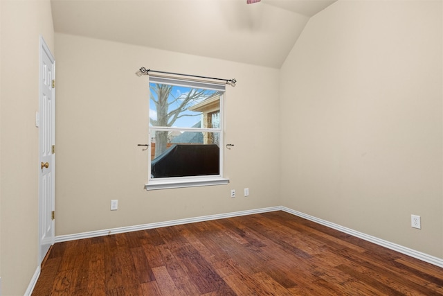 spare room featuring ceiling fan, baseboards, wood finished floors, and vaulted ceiling