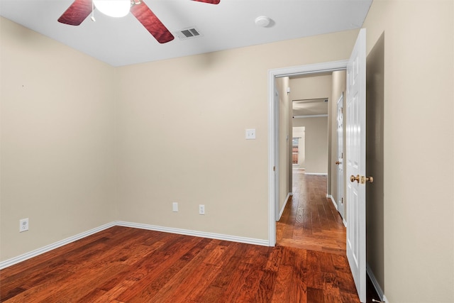 unfurnished room featuring visible vents, baseboards, wood finished floors, and a ceiling fan