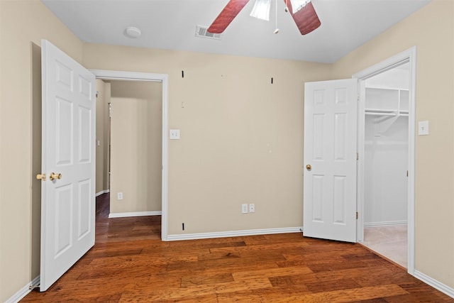 unfurnished bedroom featuring ceiling fan, wood finished floors, visible vents, and baseboards