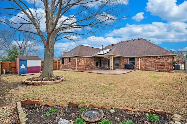 back of house featuring a fenced backyard, a patio area, a storage shed, and an outdoor structure