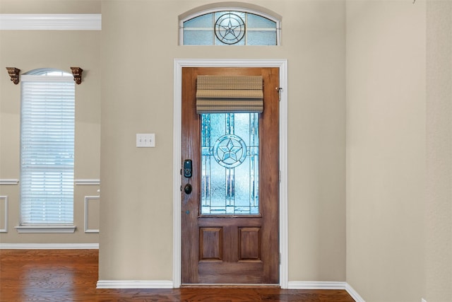 entryway featuring baseboards, wood finished floors, and crown molding