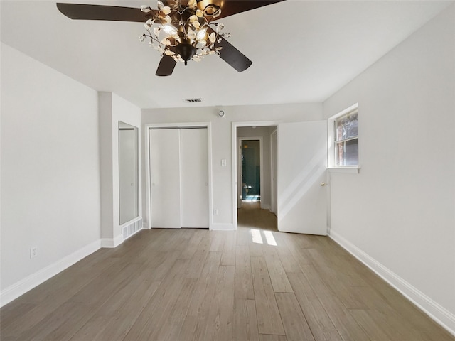 unfurnished bedroom with visible vents, baseboards, wood finished floors, and a ceiling fan