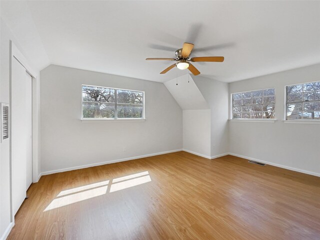 additional living space with visible vents, plenty of natural light, baseboards, and wood finished floors