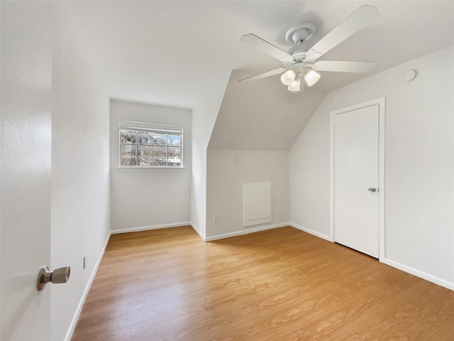 bonus room with light wood finished floors, a ceiling fan, baseboards, and vaulted ceiling