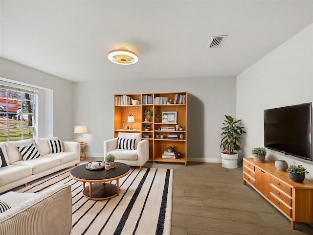 living area with visible vents, baseboards, and light wood-style flooring