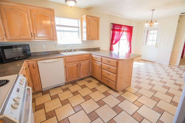 kitchen with black microwave, a peninsula, white dishwasher, stove, and a sink