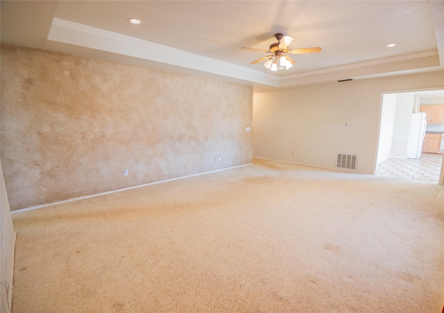 carpeted spare room featuring recessed lighting, a tray ceiling, visible vents, and ornamental molding