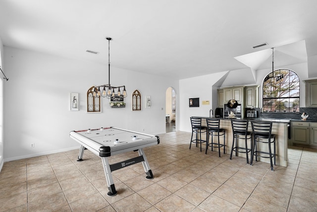 rec room with light tile patterned flooring, visible vents, arched walkways, and baseboards