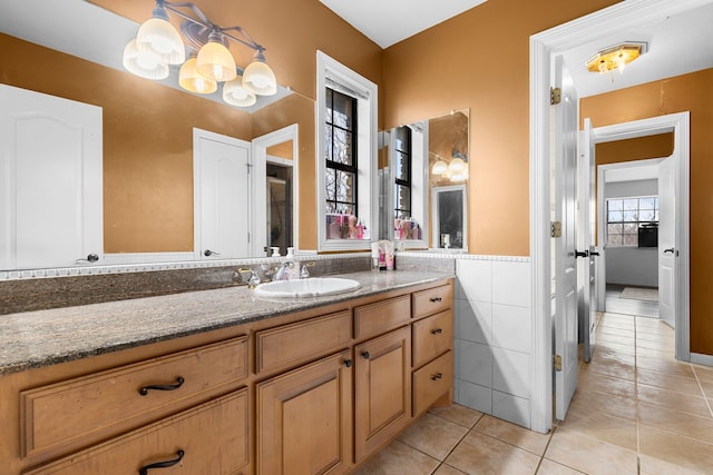 bathroom with vanity, tile walls, tile patterned floors, and wainscoting