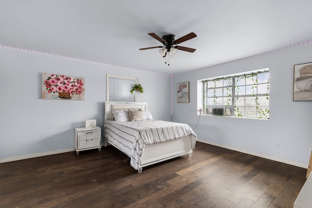 bedroom with a ceiling fan, wood finished floors, and baseboards