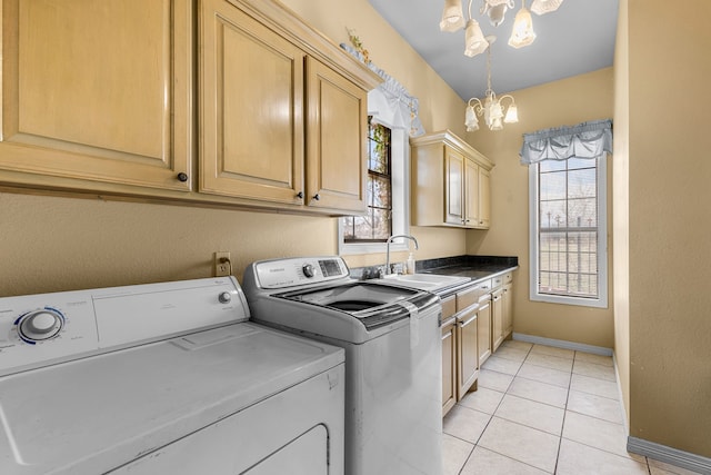 washroom featuring washing machine and clothes dryer, light tile patterned flooring, a notable chandelier, cabinet space, and a sink