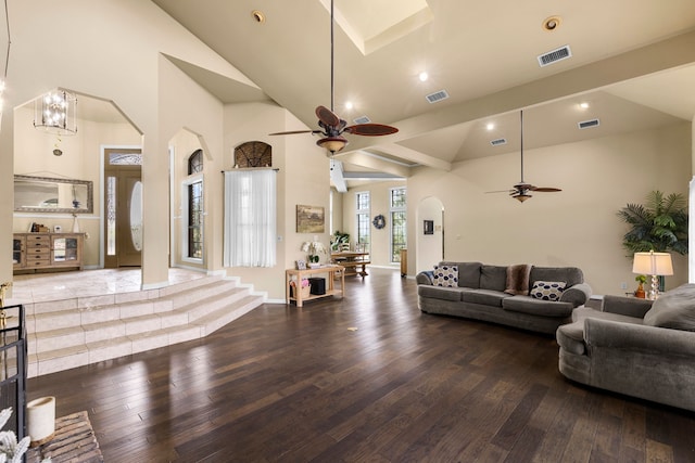 living area featuring arched walkways, visible vents, high vaulted ceiling, and wood-type flooring