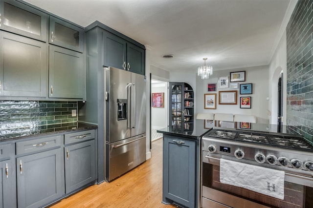 kitchen with visible vents, light wood finished floors, appliances with stainless steel finishes, crown molding, and tasteful backsplash