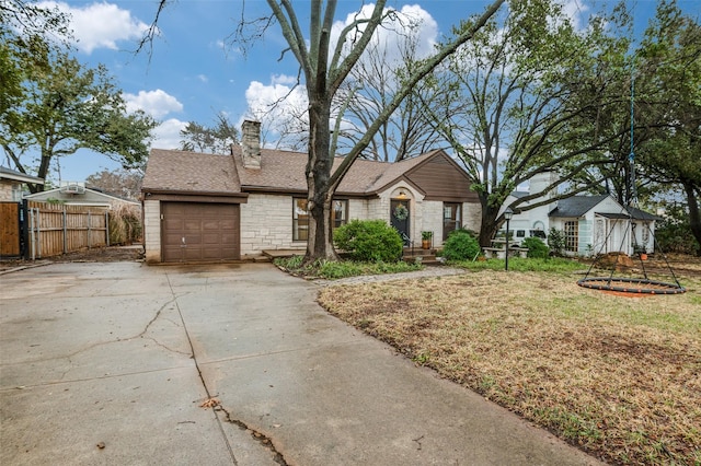 view of front of home with fence, concrete driveway, a chimney, a garage, and stone siding