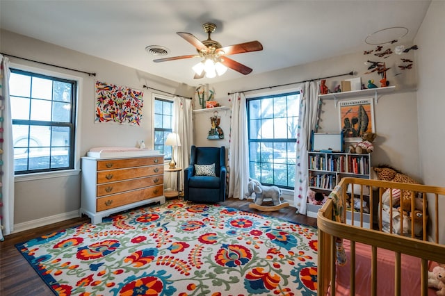 bedroom with visible vents, multiple windows, baseboards, and wood finished floors