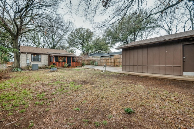 view of yard with central AC unit and fence