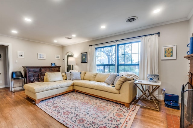 living room featuring visible vents, ornamental molding, recessed lighting, wood finished floors, and arched walkways