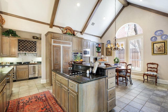 kitchen featuring a center island, a chandelier, beam ceiling, appliances with stainless steel finishes, and high vaulted ceiling