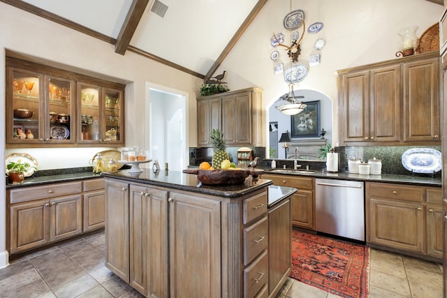 kitchen featuring visible vents, a sink, stainless steel dishwasher, a center island, and arched walkways