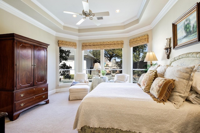 bedroom with light carpet, a tray ceiling, crown molding, baseboards, and ceiling fan