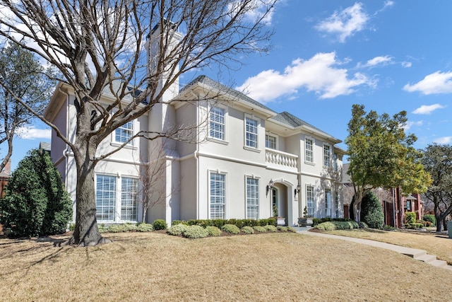 view of front of house featuring stucco siding and a balcony