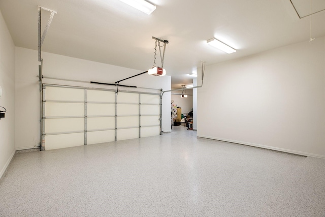 garage featuring a garage door opener and baseboards