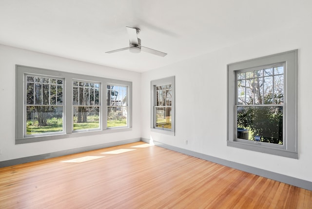 unfurnished room featuring wood finished floors, baseboards, and ceiling fan