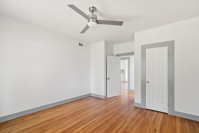 unfurnished bedroom featuring ceiling fan, visible vents, baseboards, and light wood-style flooring