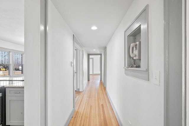 hallway with recessed lighting, baseboards, and light wood finished floors