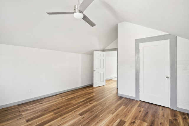 additional living space with lofted ceiling, wood finished floors, baseboards, and ceiling fan