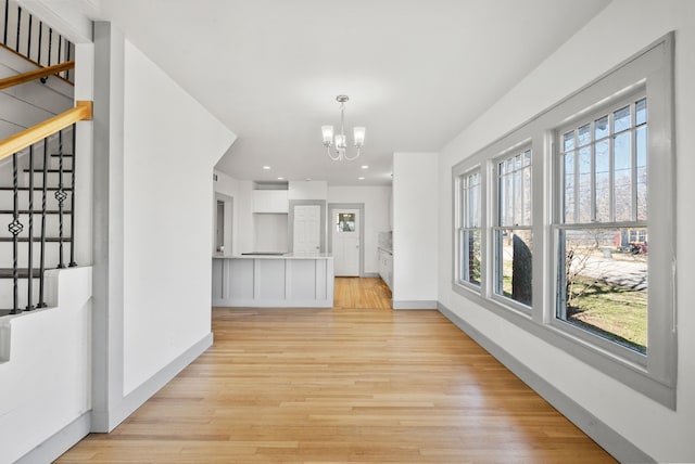 interior space with stairs, light wood-style flooring, and a chandelier