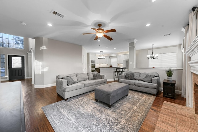 living area with visible vents, ornate columns, baseboards, recessed lighting, and dark wood-style flooring