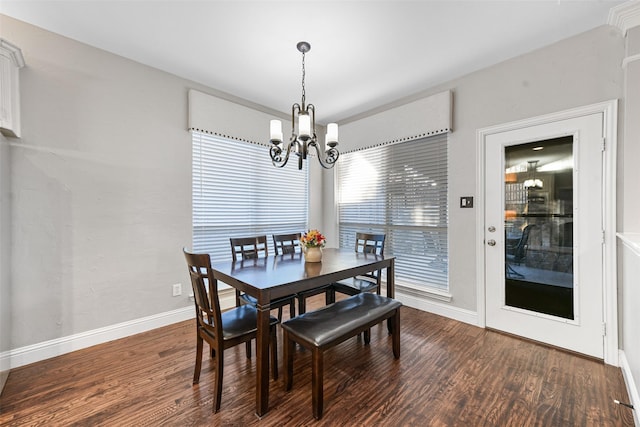 dining room featuring a chandelier, baseboards, and wood finished floors